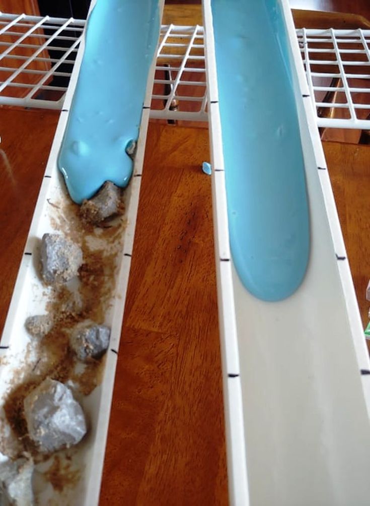 two blue and white toothbrushes sitting on top of each other in front of a wooden table