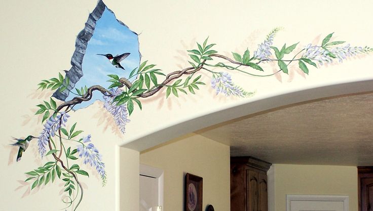 there is a mural on the wall of this house that has birds and flowers painted on it