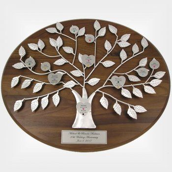 a wooden plaque with a silver tree on it's side and two names in the center