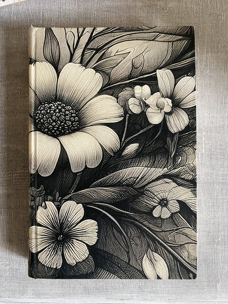 a black and white drawing of flowers on a linen covered table cloth with scissors, pens and paper