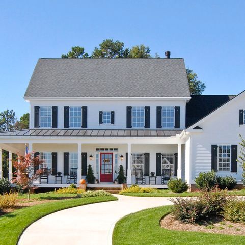 a large white house with black shutters on the front