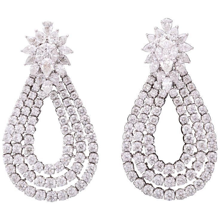 These earrings are a WOW!! Three rows of round diamonds set in a tear drop shape suspended from a fabulous cluster top. 15.60 carats of round, pear and marquise cut diamonds set in 18k white gold. Approximately 2 inches in length, approximately 1.20 inches at its widest point. A unique earring to add to any collection! Luxury Pear-shaped Diamond Evening Earrings, Pear-shaped Evening Diamond Earrings, Diamond White Teardrop Cluster Earrings For Formal Events, Diamond White Teardrop Cluster Earrings For Formal Occasions, Diamond White Pear-shaped Earrings For Evening, Pear-shaped Diamond White Diamond Earrings For Evening, Glamorous Teardrop Diamond Earrings, Pear-shaped Diamond Earrings For Evening, Formal Pear-shaped Diamond Earrings With Sparkling Stones