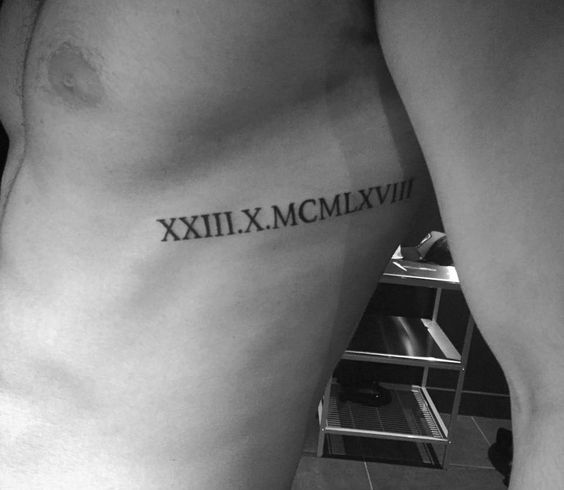 a black and white photo of a man's arm with roman numerals on it