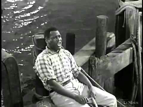 a black and white photo of a man sitting on a boat