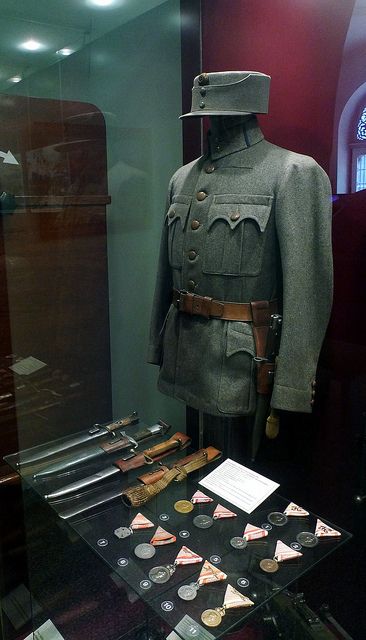 an uniform and other items on display in a glass case