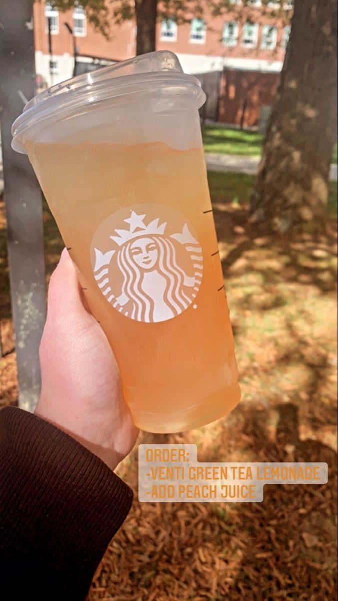 a person holding up a cup with a drink in it