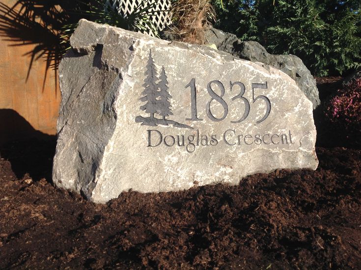 a large rock with the name of douglas crescent on it in front of some trees