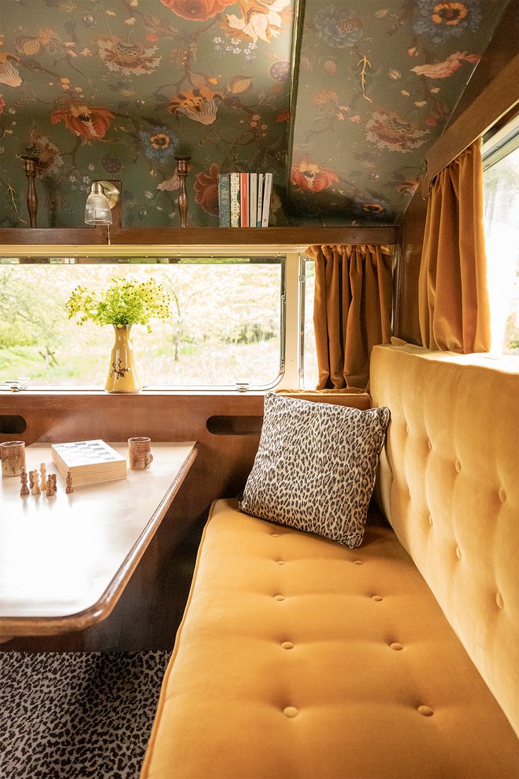 a couch and table in a room with floral wallpaper on the ceiling above it