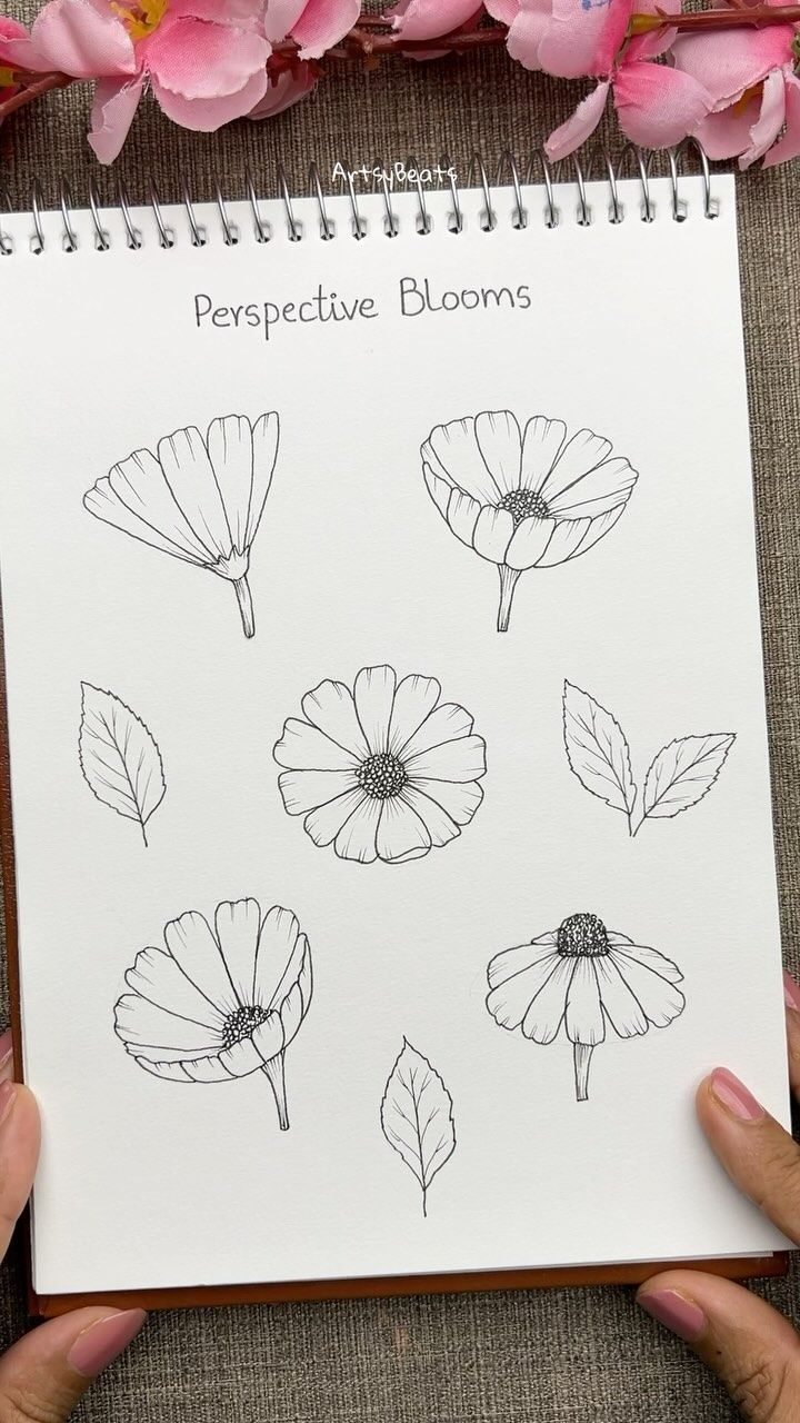 a person holding a notebook with flowers drawn on it and the words perspective blooms written in black ink