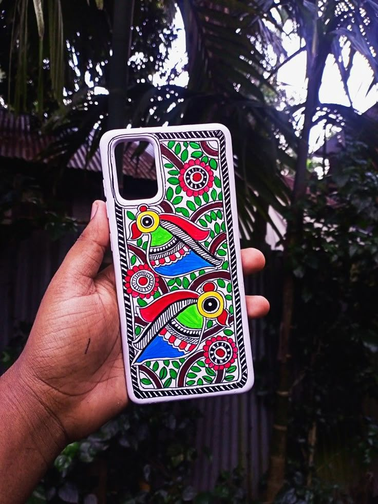 a hand holding up a phone case with colorful designs on it