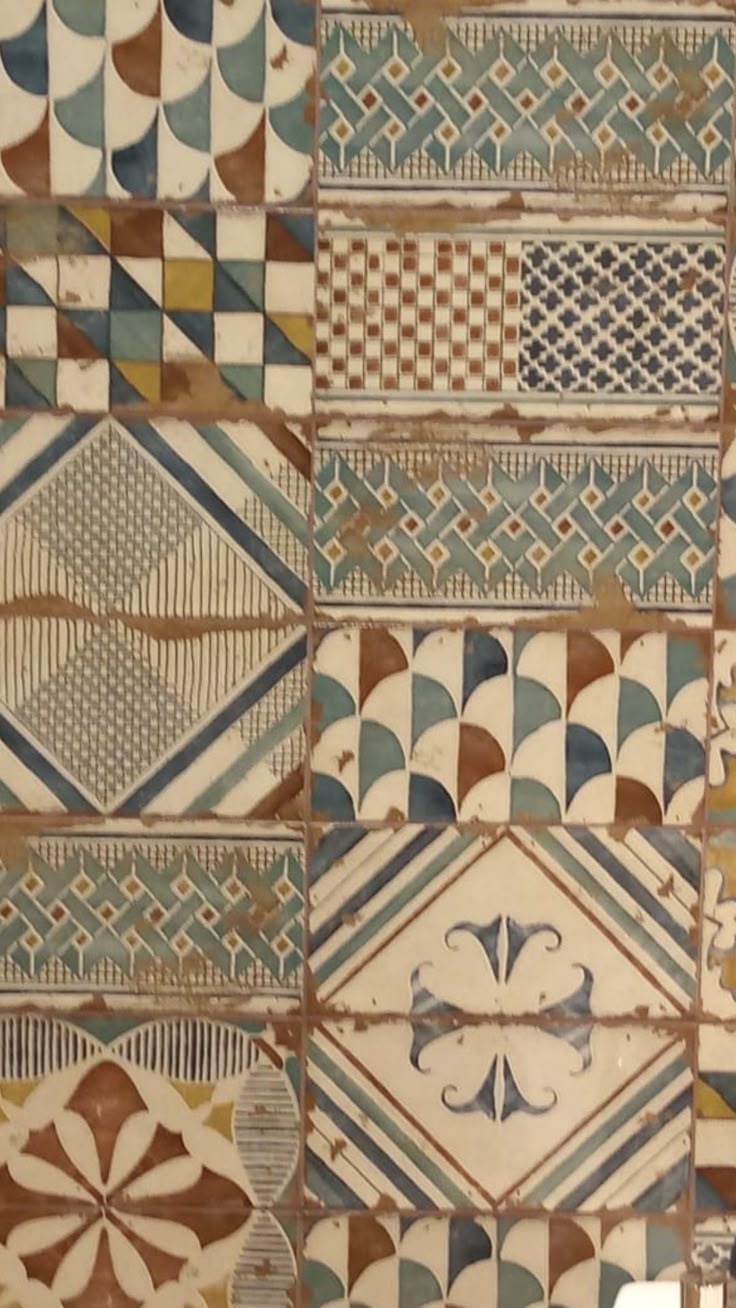 an old tile wall with different designs on it