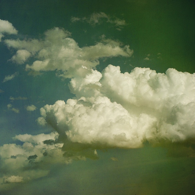 an airplane is flying in the sky with clouds