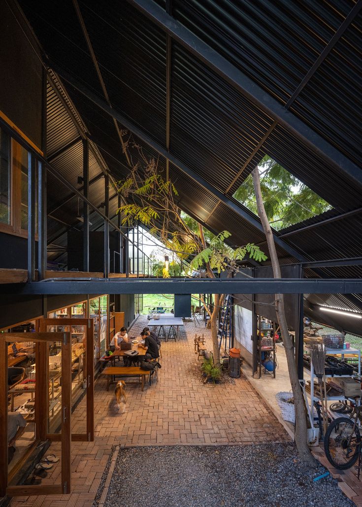 the inside of a building with people sitting at tables and bicycles parked in front of it