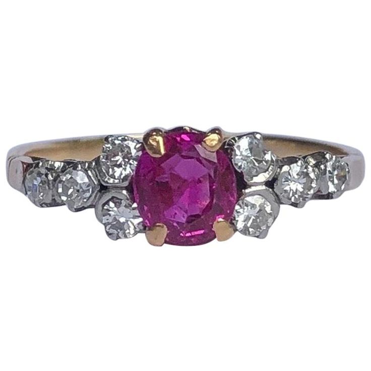 The central ruby in this ring is absolutely stunning. It is bright pink in colour and measures approx 60pts and either side of it are four smaller diamonds each measuring 5pts each. The stones are set in platinum and the rest of the ring is modelled in 18ct gold. Ring Size: N 1/2 or 7 Width: 6mm Height From Finger: 4.5mm Weight: 2.6g Pink Brilliant Cut Round Ruby Ring, Pink Brilliant Cut Ruby Ring, Pink Diamond Ruby Ring With Brilliant Cut, Pink Ruby Ring With Brilliant Cut Diamond, Classic Pink Diamond Cluster Ring, Classic Pink Cluster Ring With Center Stone, Classic Pink Ruby Ring With Center Stone, Classic Pink Diamond Ring, Classic Pink Round Diamond Ring