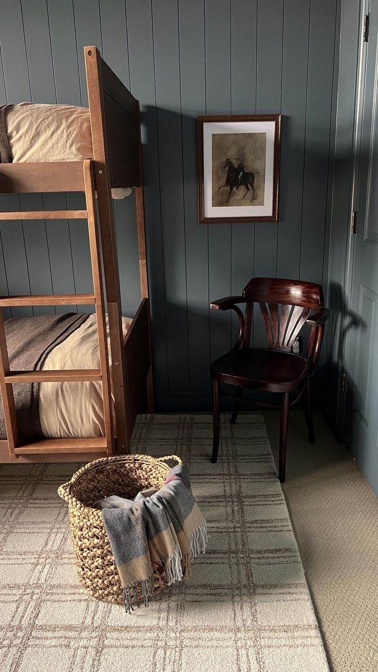 a room with two bunk beds, a chair and a rug on the floor in front of it