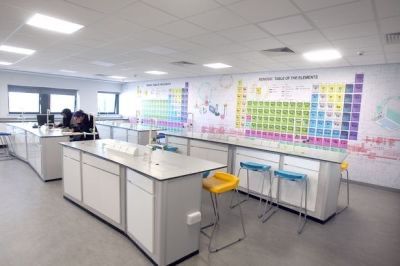 an office with desks and chairs in front of a large poster on the wall