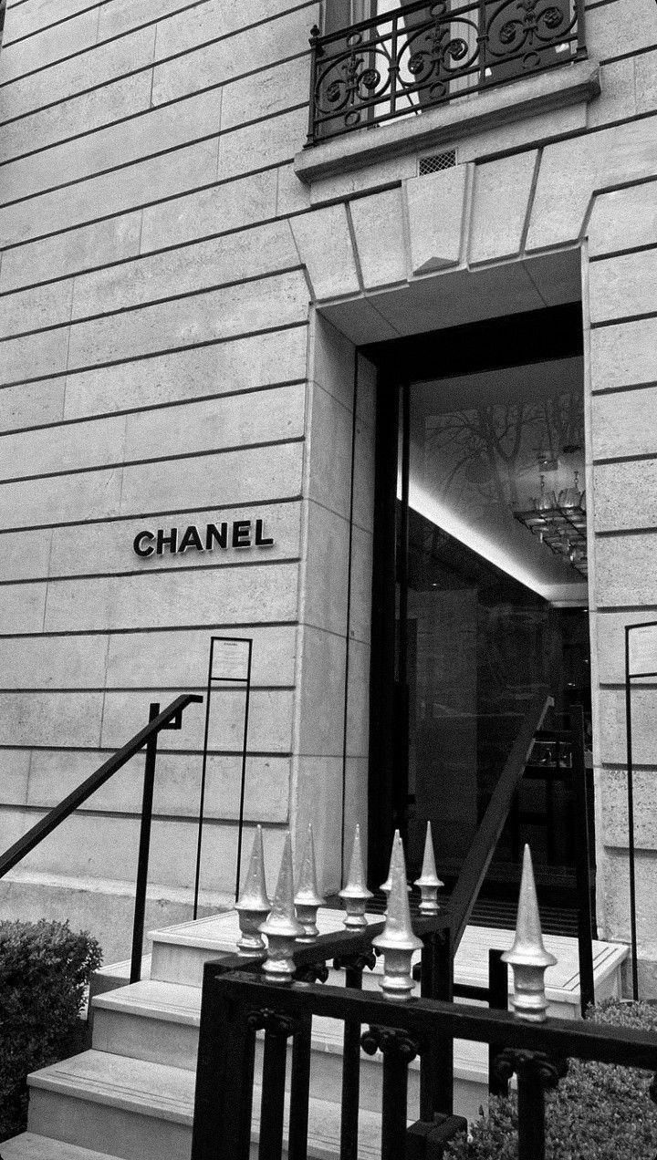 black and white photograph of chanel store front with stairs leading up to the entrance