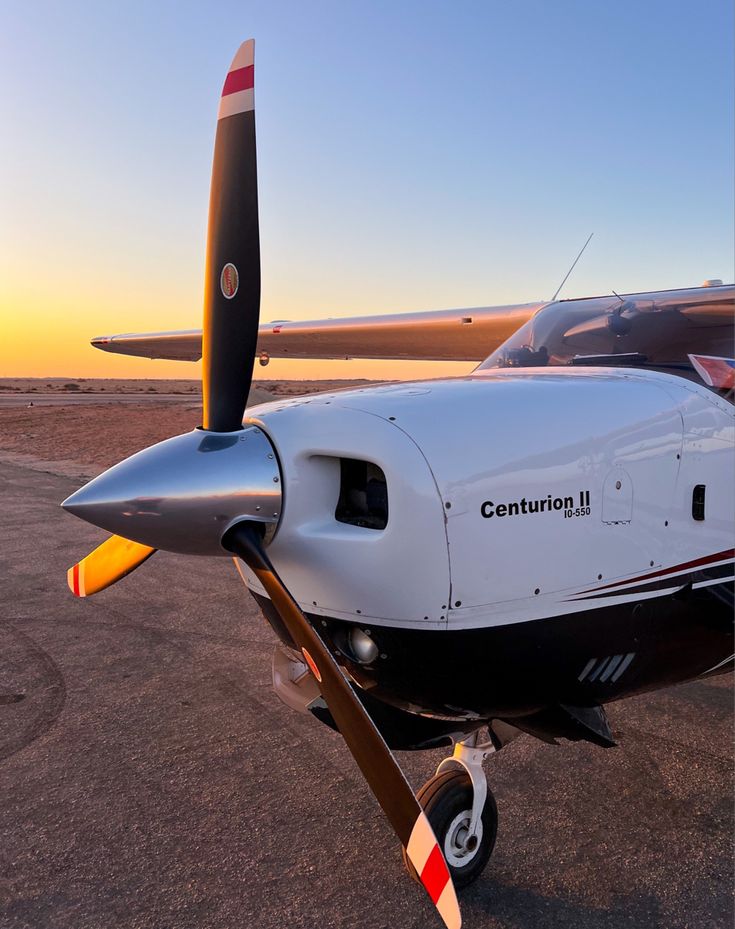 an airplane is parked on the tarmac at sunset or sunrise, with it's propellers still attached