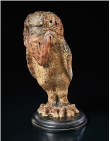 an owl figurine sitting on top of a black surface