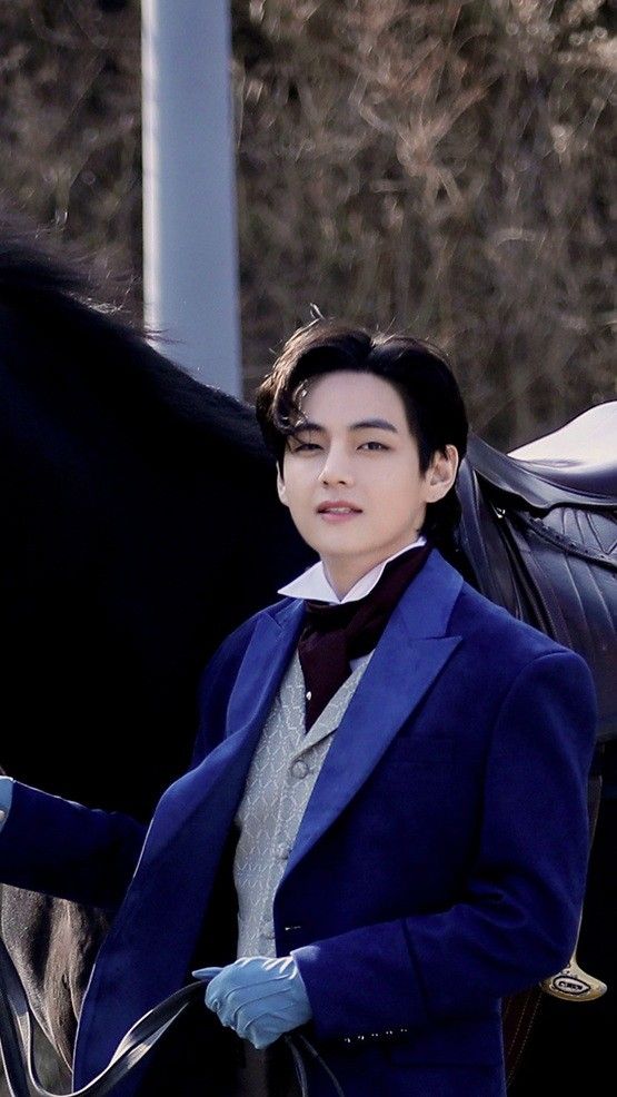 a man in a blue suit standing next to a black horse