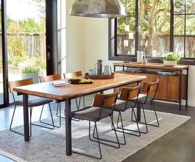 a dining room table and chairs in front of large windows