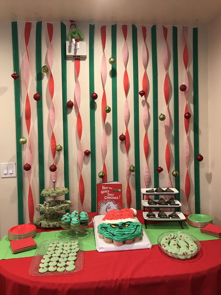 a red table topped with cakes and cupcakes on top of a green table cloth