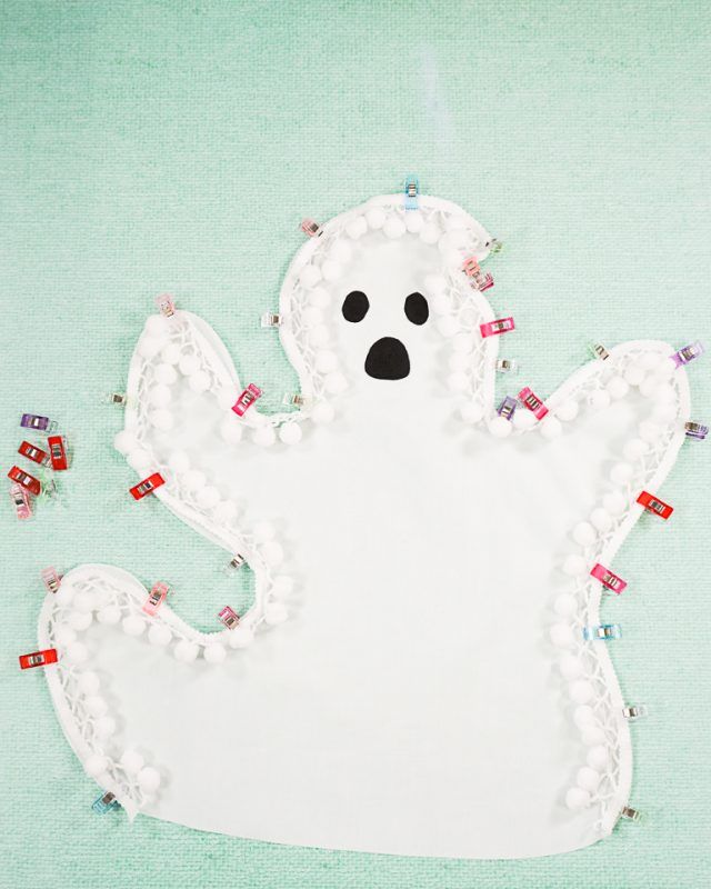 a paper cut out of a ghost with beads on it