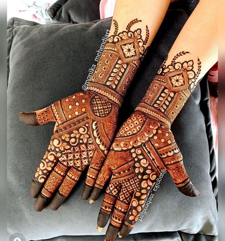 two hands with henna designs on them