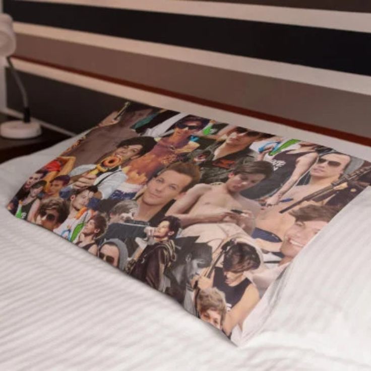 a pillow that has pictures on it sitting on a bed with white sheets and pillows