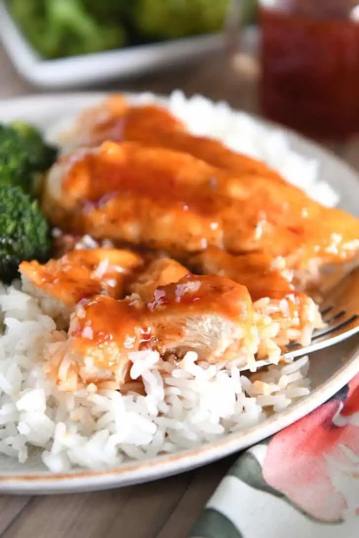 a plate with rice, broccoli and chicken covered in gravy on it