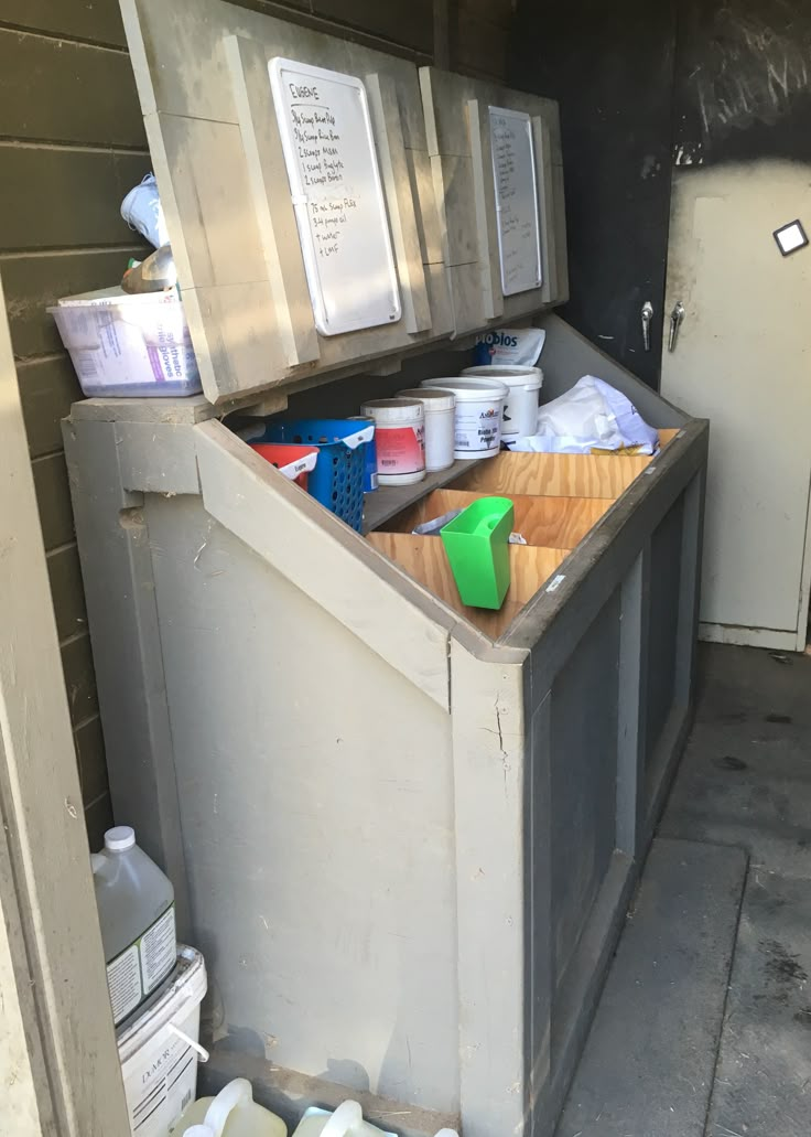 an old metal box with many items in it sitting on the side of a building