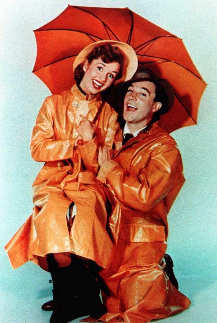 two people dressed in yellow are sitting under an umbrella