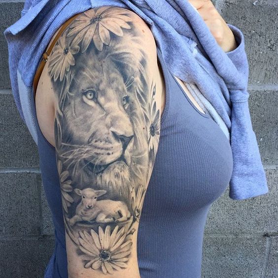 a woman with a lion and flowers tattoo on her arm is posing for the camera