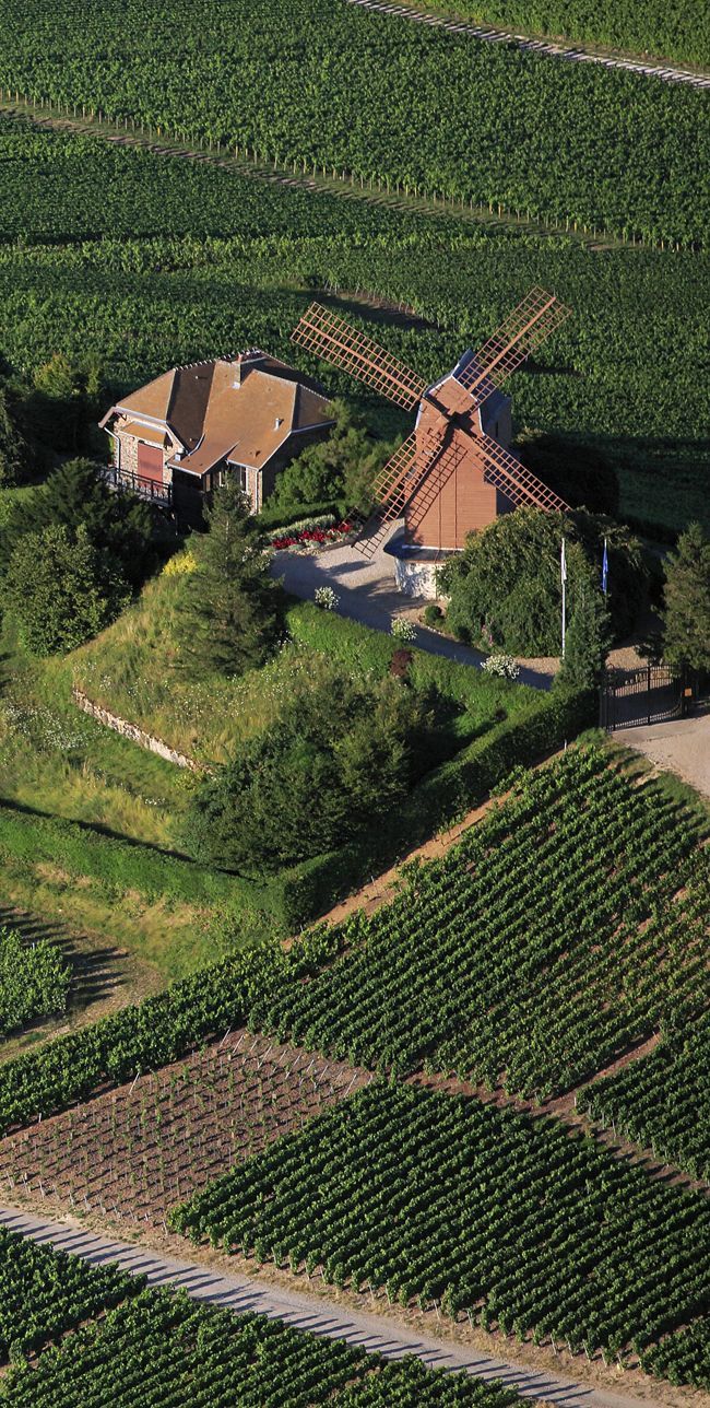 an aerial view of a farm house and windmill