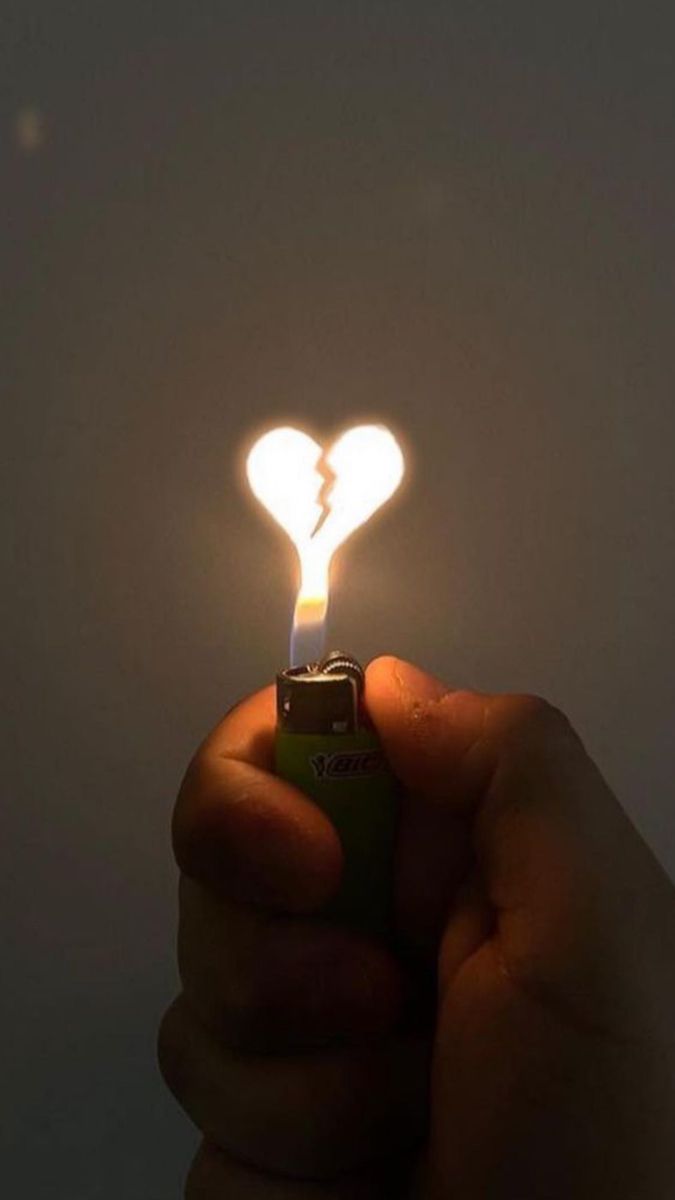 a person holding a lighter with a heart shaped light on it