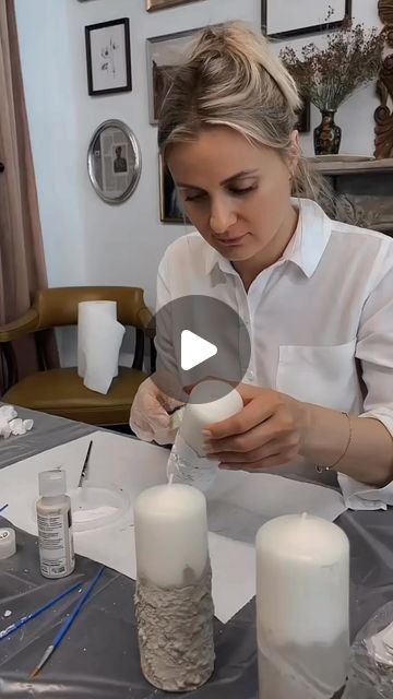 a woman sitting at a table with some candles