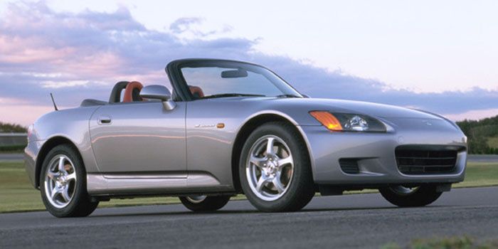 a silver sports car driving down a road