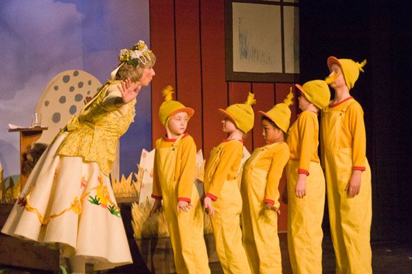 a group of children in yellow outfits on stage