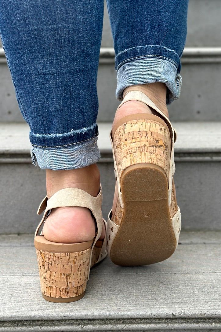 Sophistication, classic style, and comfort meet in the Romy Sandal. With gold buckle and stud detailing, and an elastic ankle strap, these wedges are sure to become a go-to shoe for the summer. mixed material // chunky cork sole // stud & buckle detailing Heel Height: 3.25" Chic Cork Sandals With Open Toe, Chic Cork Sandals With Round Toe, Spring High Heel Cork Sandals, Chic Cork Wedge Sandals With Open Toe, High Heel Cork Sandals For Spring, Chic Open Toe Cork Wedge Sandals, Summer Cork Wedge Heels, Chic Cork Wedge Sandals For Spring, Chic Cork Sandals For Summer