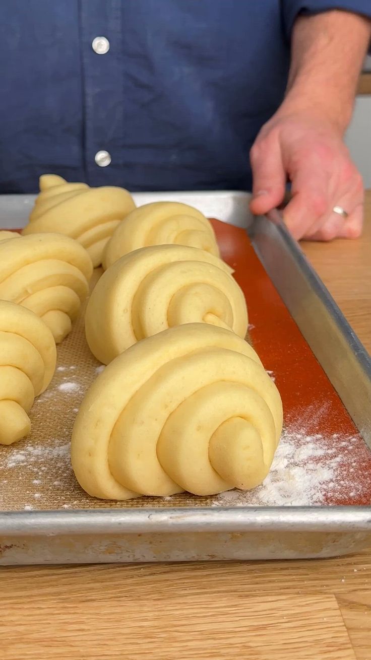 a person is cutting up some food on a table with a knife and cookie sheet