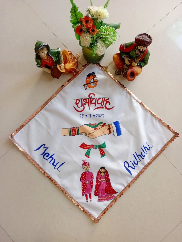 an embroidered cloth with the names of different people on it and flowers in vases