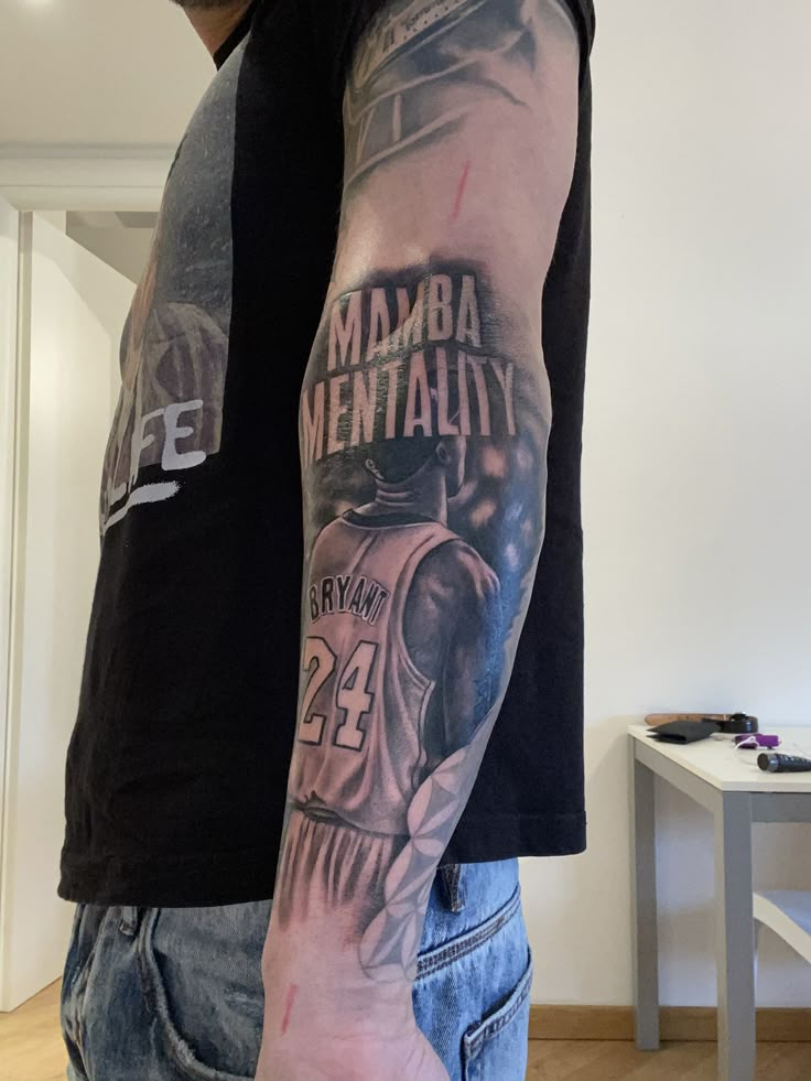 a man with a tattoo on his arm that reads mamba mentality and is holding a basketball