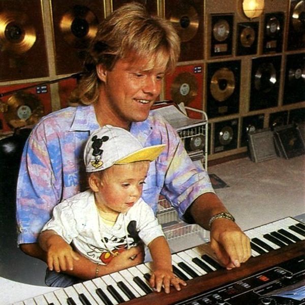 a man is playing the keyboard with his child