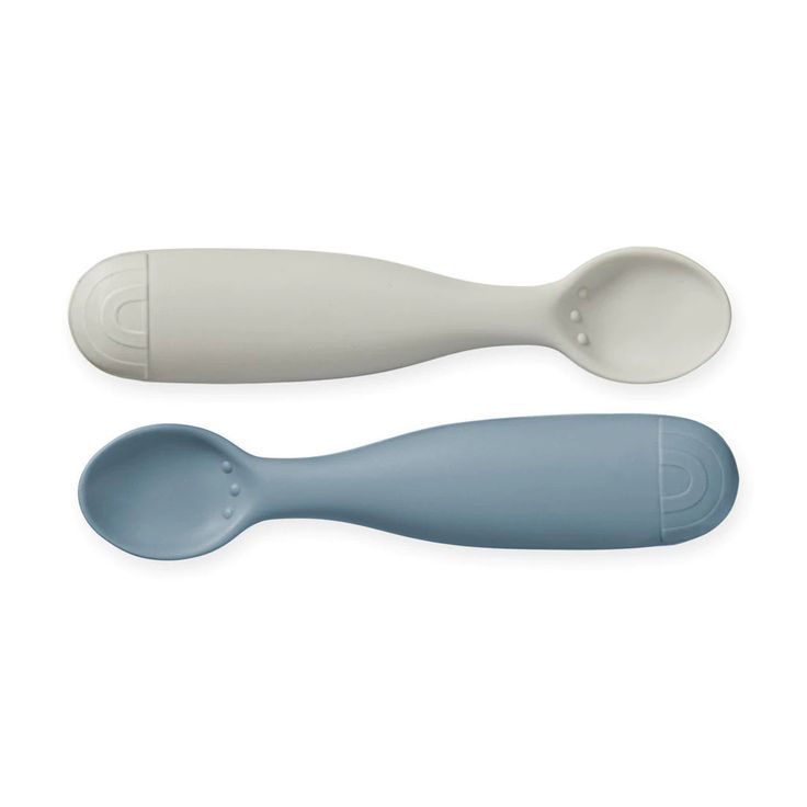 two spoons sitting next to each other on a white surface