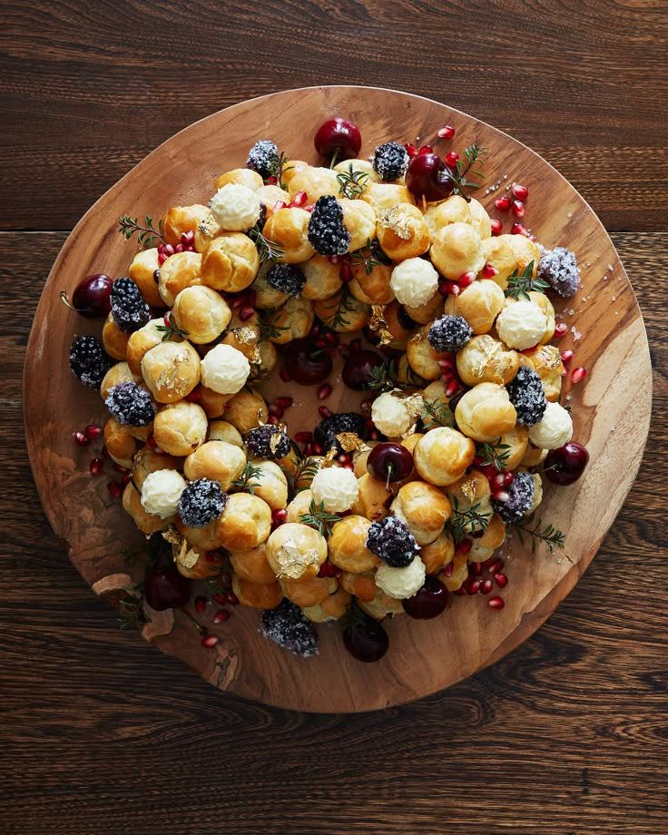 a wooden plate topped with fruit and pastry