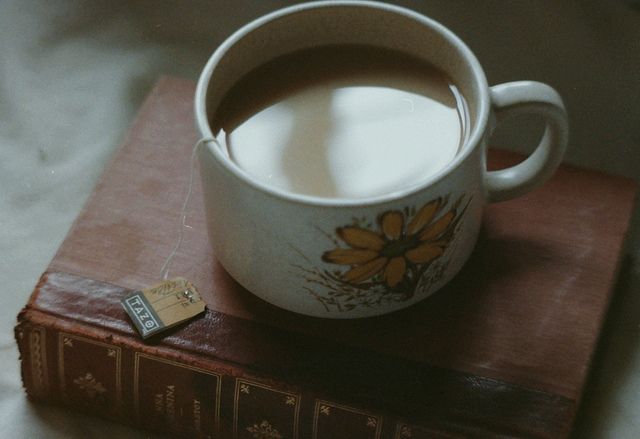 a cup of coffee sitting on top of a book