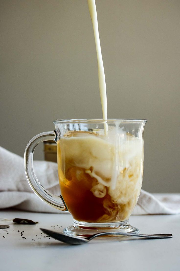 a glass mug filled with liquid being poured into it