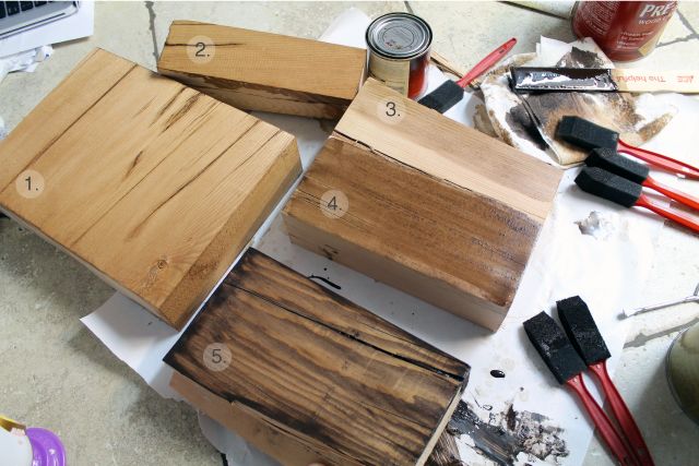 several pieces of wood sitting on top of a table next to paintbrushes and other tools