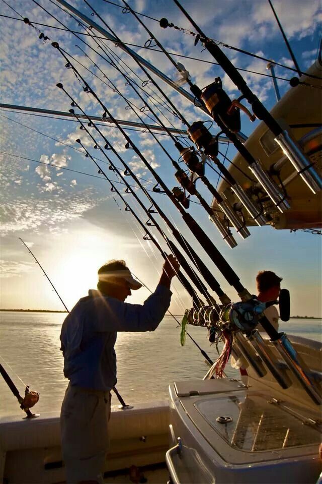 two men on a boat with fishing rods