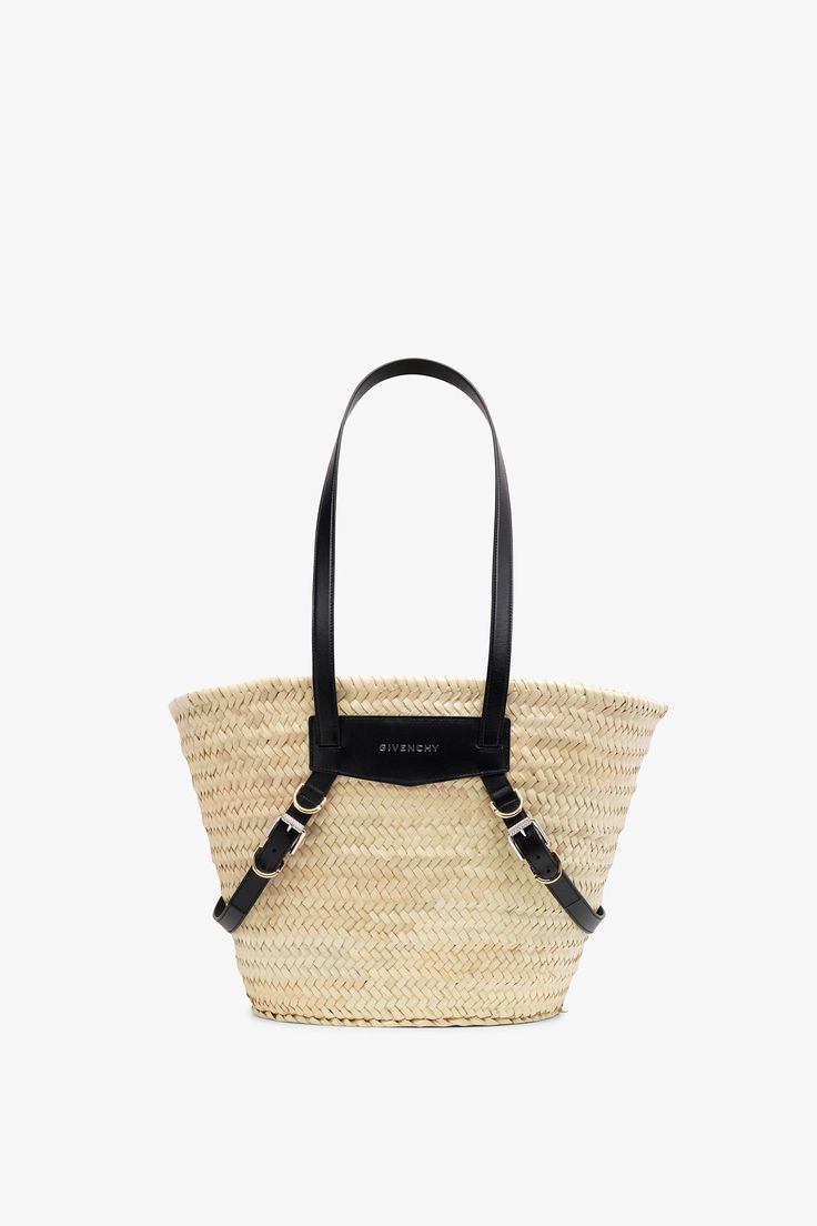 Beige and black raffia tote bag from Givenchy. The Plage Voyou tote bag is made of hand-crafted raffia, featuring transversal leather straps with gold and silver-finish Givenchy engraved metal buckles, along with black leather handles offering a practical long shoulder carry. It is complete with one main compartment.Measurements: L46 x H32 x W26,5 cmMade in Italy Raffia Tote Bag, Engraved Metal, Beige And Black, Metal Engraving, Leather Handles, Black Bag, Metal Buckles, Leather Handle, Givenchy